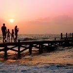 family on pier at sunset