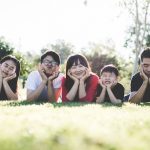 smiling family laying together in grass